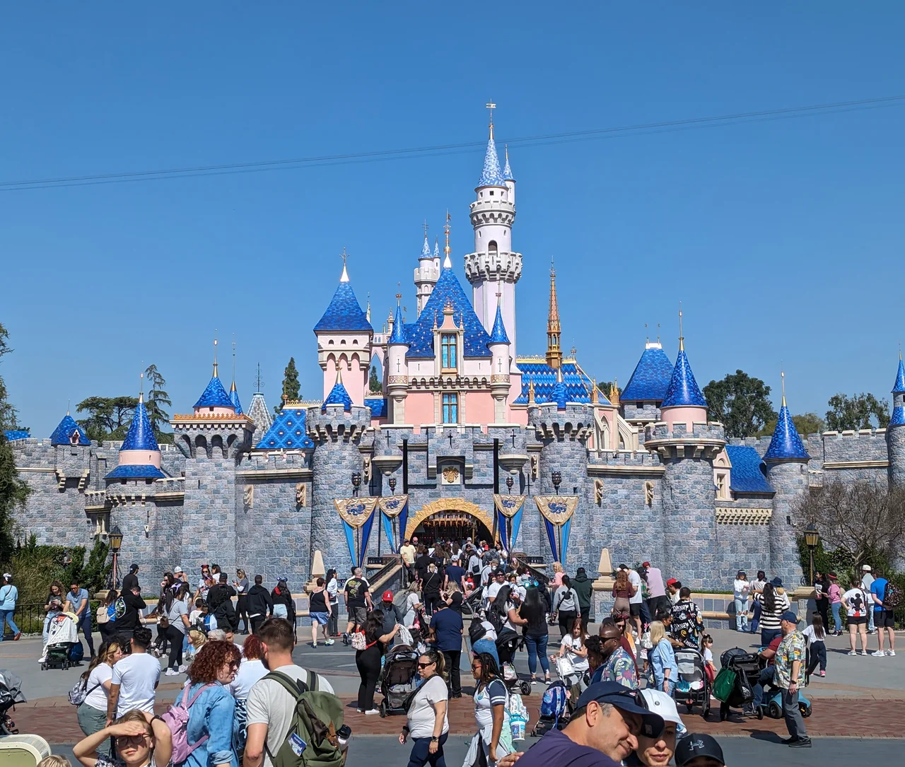 Sleeping Beauty Castle at Disneyland Paris, its blue spires rising above the Central Plaza on a clear day