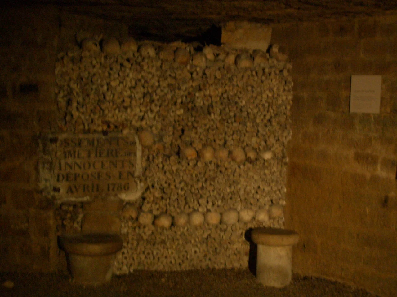 Rows of skulls and carefully stacked bones in the Paris Catacombs